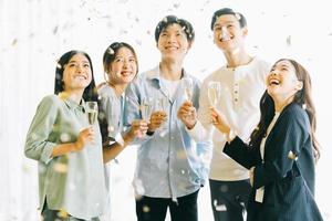 asiatische Geschäftsleute stoßen ihre Gläser an und feiern die Ergebnisse foto