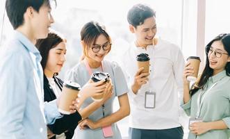 Gruppe von Geschäftsleuten plaudert und trinkt Kaffee während der Pause foto