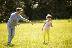 Vater jagt seine kleine Tochter beim Spielen im Park
