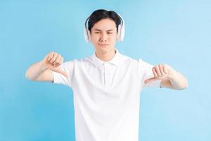 asiatischer Mann mit unangenehmem Blick beim Musikhören