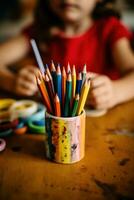 ein Kind ist Zeichnung mit farbig Buntstifte im ein Bleistift Halter ai generativ foto