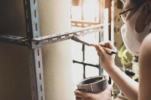 do it yourself-Konzept, Handwerker verwenden Rostschutzfarbe, um alte Eisenteile zu lackieren mach ein regal an deinem freien wochenende