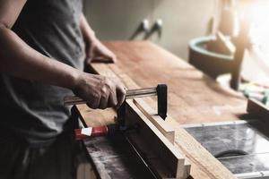 Holzbearbeitungsarbeiter dekorieren Holzstücke, um Holztische für den Kunden zu montieren und zu bauen