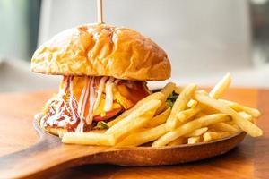 Rinderburger mit Käse und Sauce auf Holzteller foto