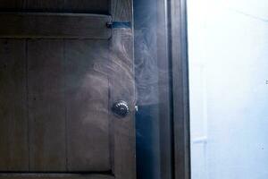 ein Ohnmacht Wolke von Rauch trieb Vergangenheit das Tür, geben ein klar Sicht. foto