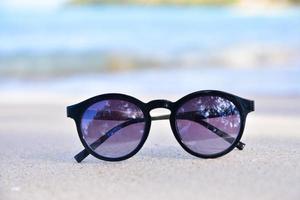 sonnenglas ist auf strand meerblick hintergrund, sommerferienkonzept