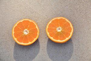 Orangenscheibe auf Sand am Strand Meer foto