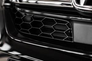 Gitter des weißen Sportwagens. der Kühlergrill. Metall Textur. Chrom-Kühlergrill eines großen mächtig. vor dem Auto. Kühlergrill von Luxussportwagen. Kunststoff- oder Metallgitter. Kühlergrill foto