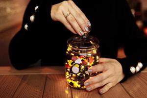 junge Frau, die Flasche Medizin zeigt. farbige Kapseln. verschiedene medizinische Kapsel verschüttet aus einem Glas. Medizinkonzept foto