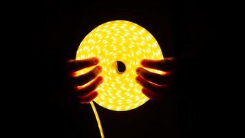 Spule aus leuchtendem LED-Streifen mit warmem Licht in der Hand foto