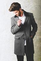 hübscher junger Mann mit Mantel. Studioaufnahme foto