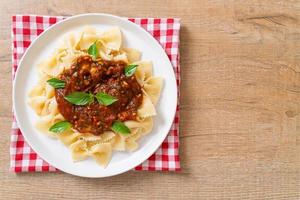 Farfalle Nudeln mit Basilikum und Knoblauch in Tomatensauce - italienische Sauce foto