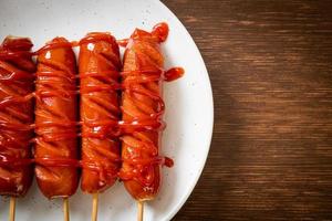 Bratwurstspieß mit Ketchup auf einem weißen Teller foto