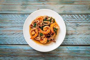 gebratene Meeresfrüchte von Garnelen und Tintenfisch mit thailändischem Basilikum - asiatische Küche foto