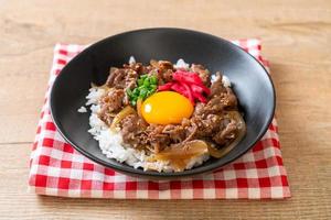 Rindfleisch in Scheiben auf belegtem Reis mit Ei oder Gyudon - japanische Küche foto