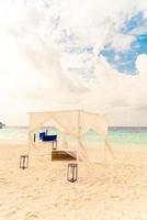 Hochzeitsbogen am Strand mit tropischem Malediven-Resort und Meereshintergrund foto