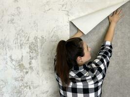 Brünette Frau mit Neu grau Mauer Papier foto