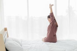 asiatische Frau im Bett und morgens aufwachen