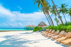 Strandkörbe mit tropischem Strand und Meer auf den Malediven - Urlaubshintergrundkonzept foto