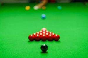 Spieler schoss Ball auf grünem Snookertisch foto