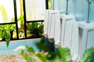 Reihe weißer Urinale in der Männertoilette foto