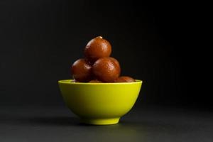 Gulab Jamun in Schüssel auf schwarzem Hintergrund. indisches Dessert oder süßes Gericht. foto