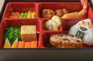 Inari-Sushi-Reis umhüllt von getrocknetem Tofu mit gebratenen Garnelen und gebratenem Hühnchen im Bento-Set - japanische Küche foto