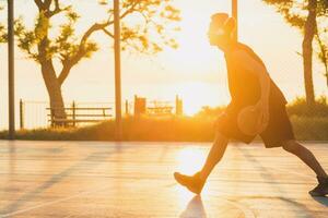 schwarz Mann tun Sport, spielen Basketball auf Sonnenaufgang, aktiv Lebensstil, sonnig Sommer- Morgen foto