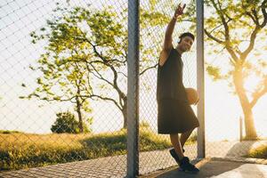 schwarz Mann tun Sport, spielen Basketball auf Sonnenaufgang, aktiv Lebensstil, sonnig Sommer- Morgen foto