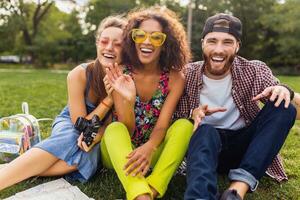 glücklich jung Unternehmen von freunde Sitzung Park foto