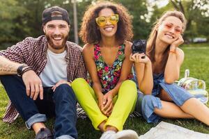 glücklich jung Unternehmen von freunde Sitzung Park foto