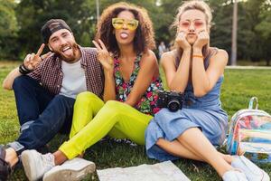 glücklich jung Unternehmen von freunde Sitzung Park foto