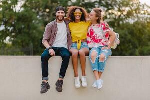 glücklich jung Unternehmen von lächelnd freunde Sitzung im Park foto