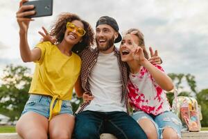 glücklich jung Unternehmen von lächelnd freunde Sitzung im Park foto