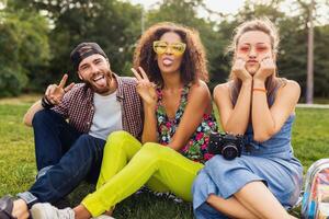 glücklich jung Unternehmen von freunde Sitzung Park foto