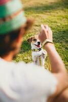 jung stilvoll Hipster Mann Gehen spielen Hund Hündchen Jack Russell foto