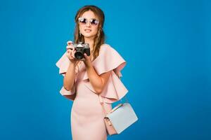 jung stilvoll sexy Frau im Rosa Luxus Kleid nehmen Bilder auf Jahrgang Kamera foto