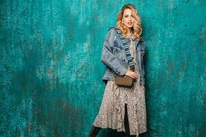 attraktiv stilvoll blond Frau im Jeans Übergröße Jacke Gehen gegen Mauer Mode foto