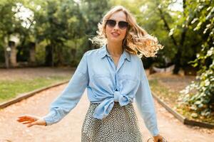 stilvoll blond Frau Gehen im Straße Park Sommer- Mode foto