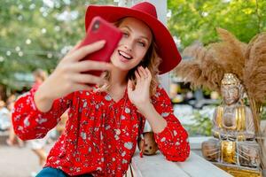 attraktiv stilvoll blond lächelnd Frau im Stroh rot Hut und Bluse Sommer- Mode foto