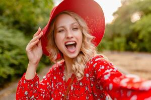 attraktiv stilvoll blond lächelnd Frau im Stroh rot Hut und Bluse Sommer- Mode foto