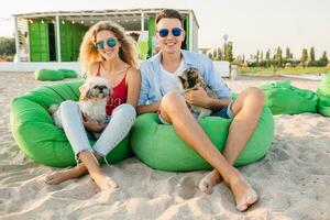 jung attraktiv lächelnd Paar haben Spaß auf Strand spielen mit Hunde foto