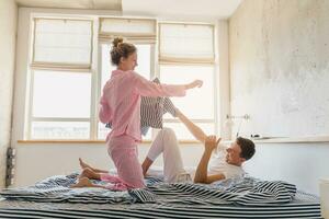 komisch jung Paar haben Spaß auf Bett im Morgen foto