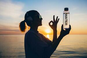 Frau beim Meer halten Flasche von Wasser foto