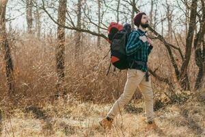 jung Hipster Mann Reisen mit Rucksack im Frühling Herbst Wald foto