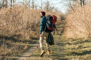 jung Hipster Mann Reisen mit Rucksack im Frühling Herbst Wald foto