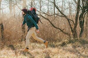 jung Hipster Mann Reisen mit Rucksack im Frühling Herbst Wald foto