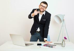 jung gut aussehend stilvoll Hipster Mann im schwarz Jacke Arbeiten beim Büro Tabelle foto