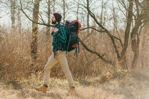 jung Hipster Mann Reisen mit Rucksack im Frühling Herbst Wald foto