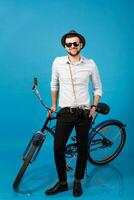 jung gut aussehend lächelnd glücklich Mann Reisen auf Hipster Fahrrad foto